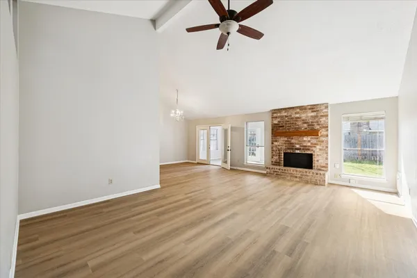 wooden floor fireplace and windows in an empty room