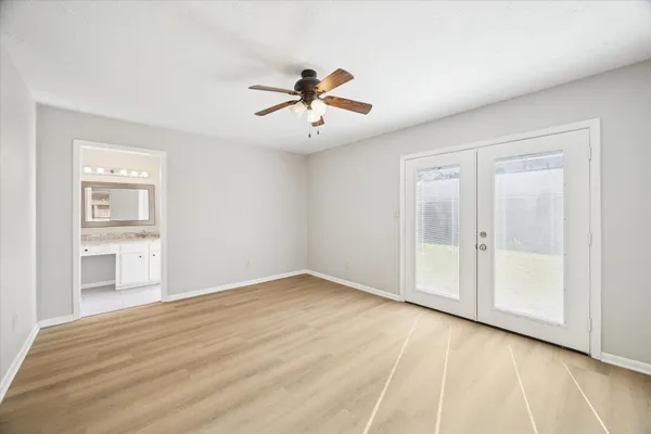 a view of empty room with wooden floor and ceiling fan