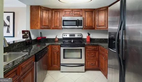 a kitchen with stainless steel appliances granite countertop a stove a refrigerator and a sink