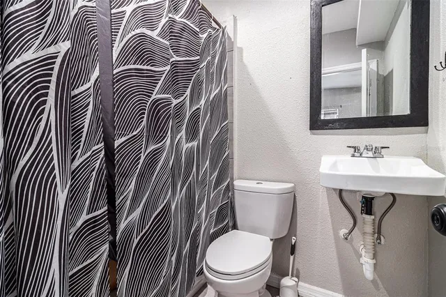 a bathroom with a sink a toilet and mirror