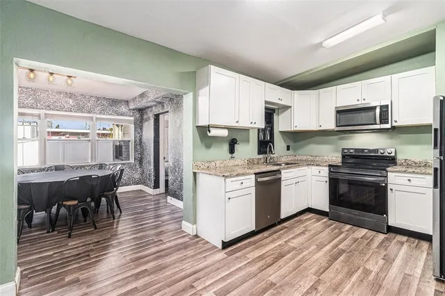 a kitchen with a sink stove and white cabinets