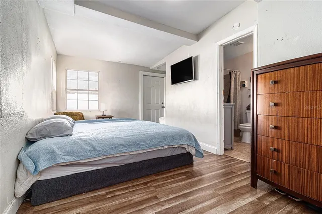 a bedroom with a bed and a flat screen tv