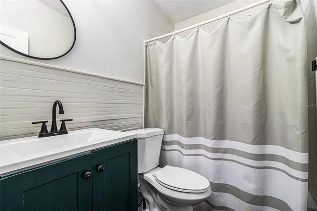 a bathroom with a sink a toilet and a mirror