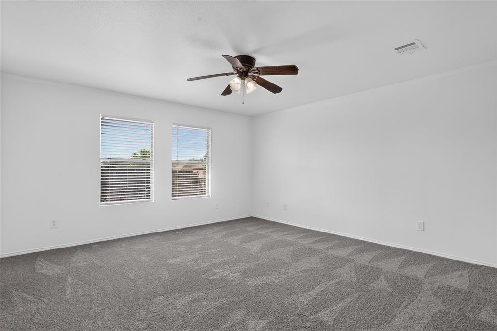12933 Azure Heights Place Rhome, TX 76078 - Photo 27 of 37 Spacious room featuring patterned carpeting, two windows with blinds, a ceiling fan with integrated lighting, and white walls