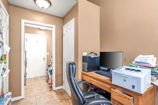 a view of a workspace with furniture and a window