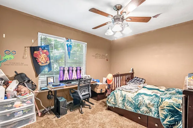 a bedroom with a bed bookshelf and a window