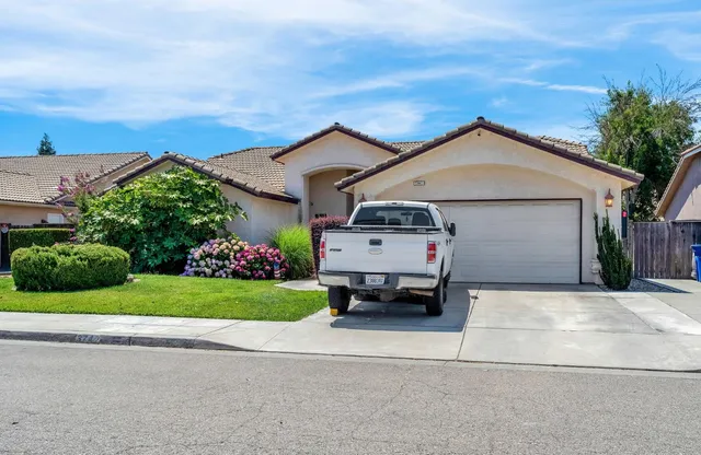 front view of a house with a yard and potted plants