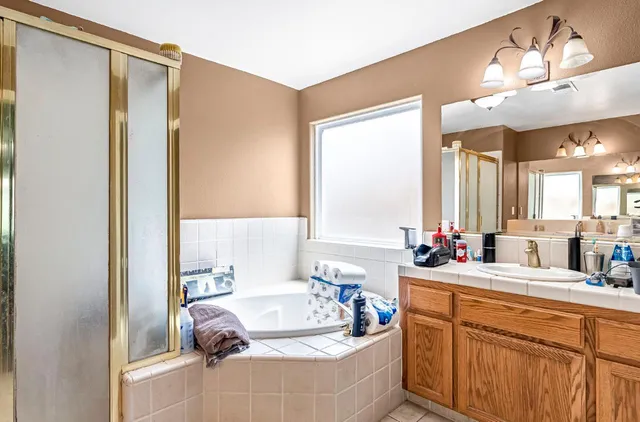 a bathroom with a tub sink and mirror