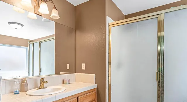 a bathroom with a granite countertop sink and a mirror