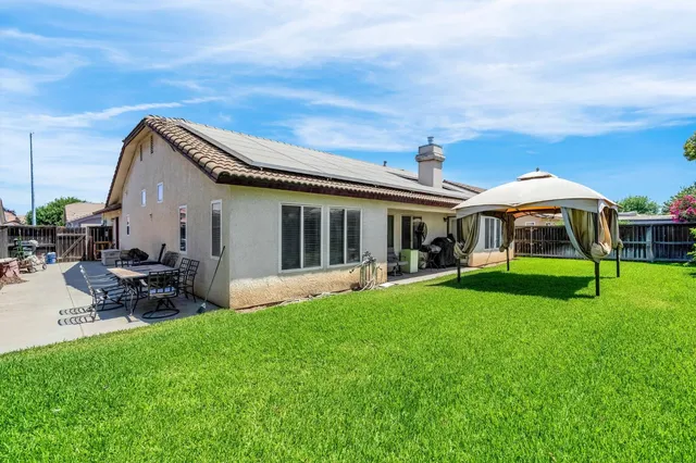 a front view of house with yard and outdoor seating