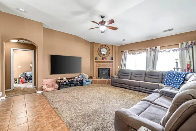 a living room with furniture ceiling fan and a flat screen tv