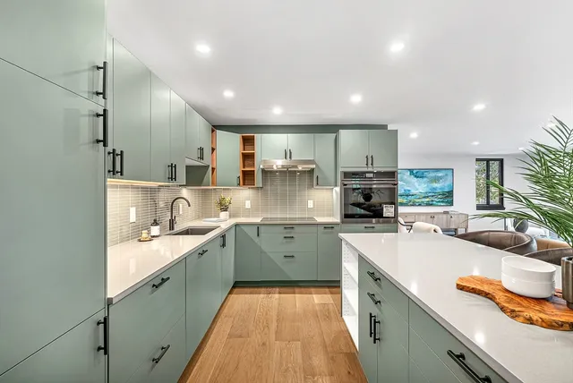 a large kitchen with stainless steel appliances lots of counter space sink and a wooden floor