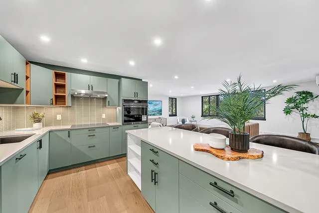 a kitchen with stainless steel appliances granite countertop sink a refrigerator a stove top oven