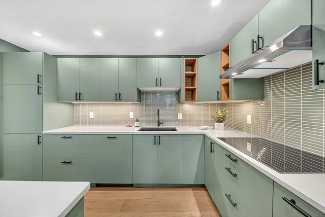 a kitchen with a sink a counter space cabinets and appliances