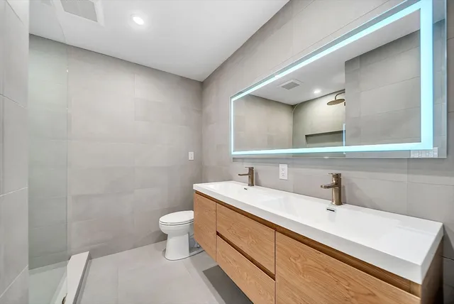 a bathroom with a sink a toilet and a mirror