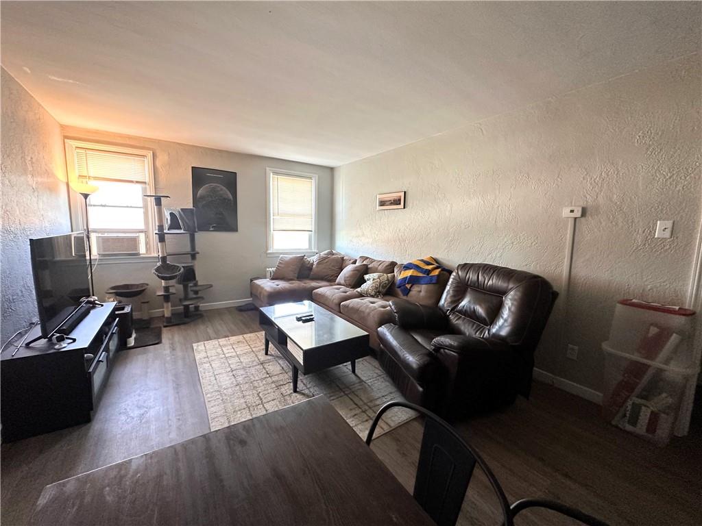 422 Mill Street, Unit D Coraopolis, PA 15108 - Photo 4 of 6 a living room with furniture a wooden floor and a flat screen tv