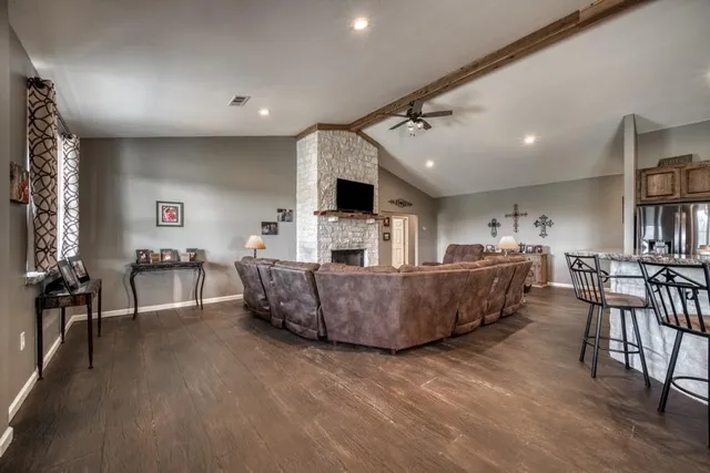 a living room with furniture a flat screen tv and a fireplace
