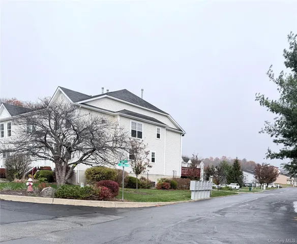 a white house that has tree in front of it