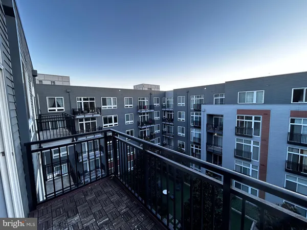 a hallway with wooden floor windows and a rug