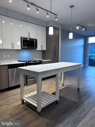 a kitchen with stainless steel appliances granite countertop a sink a stove and a wooden floors
