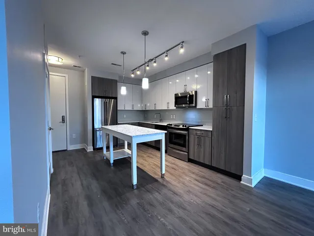 a kitchen with stainless steel appliances kitchen island hardwood floor sink stove and cabinets