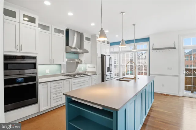 a kitchen with kitchen island granite countertop a stove a sink and a refrigerator