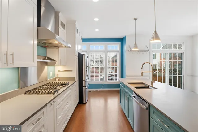 a kitchen with kitchen island a stove a sink and wooden floor