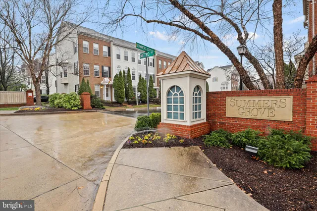 a view of a house with a yard and large trees