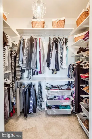 a view of walk in closet with clothes and shoes