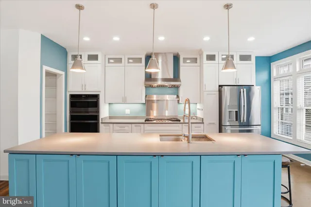 a kitchen with kitchen island a stove a sink and a refrigerator with wooden floor
