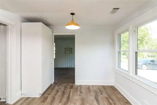 a view of a room with wooden floor and a window