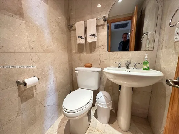 a bathroom with a sink toilet and a mirror