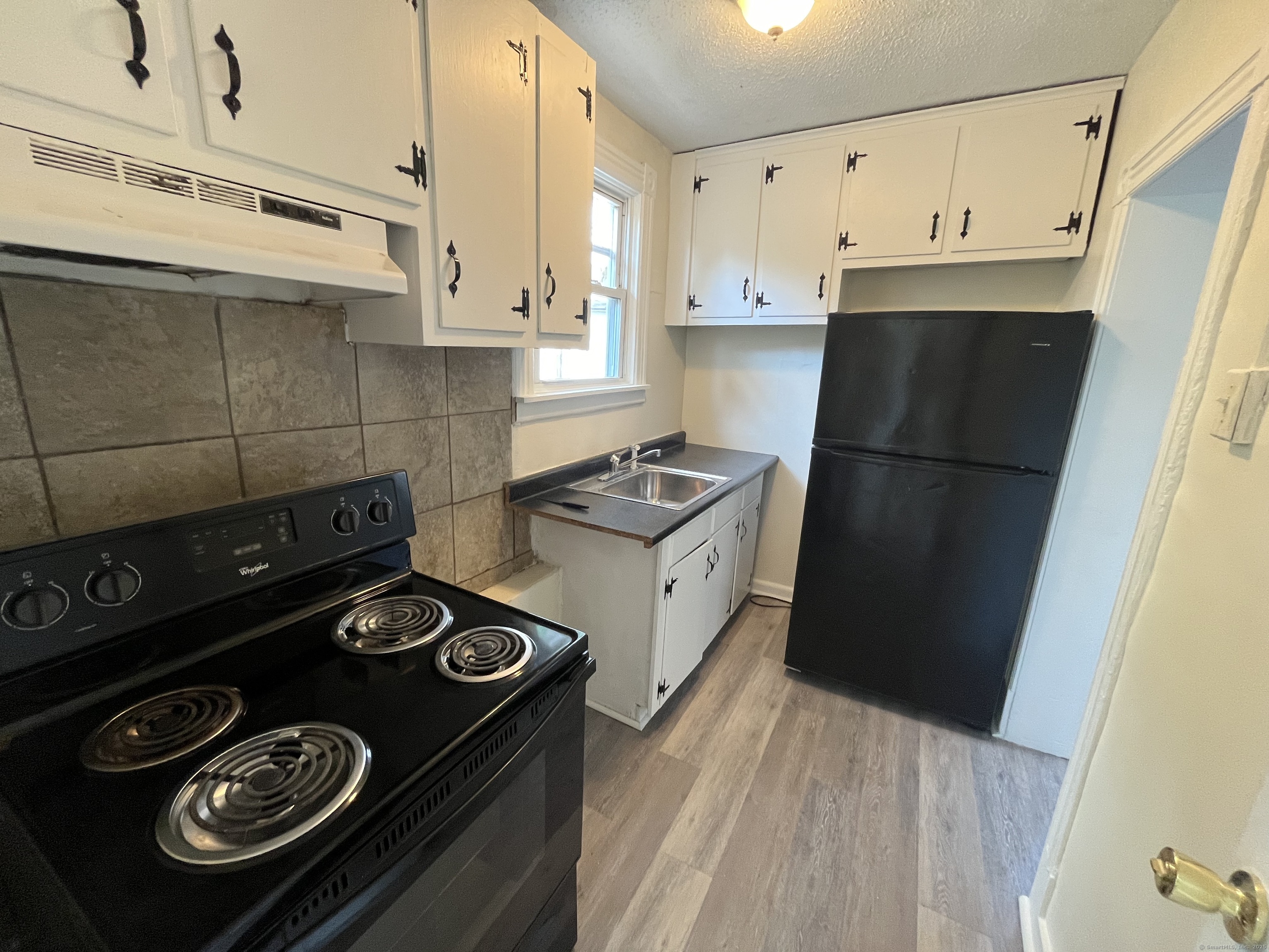 144 Burnham Street, Unit 2 Hartford, CT 06112 - Photo 2 of 11 a kitchen with a stove and a refrigerator