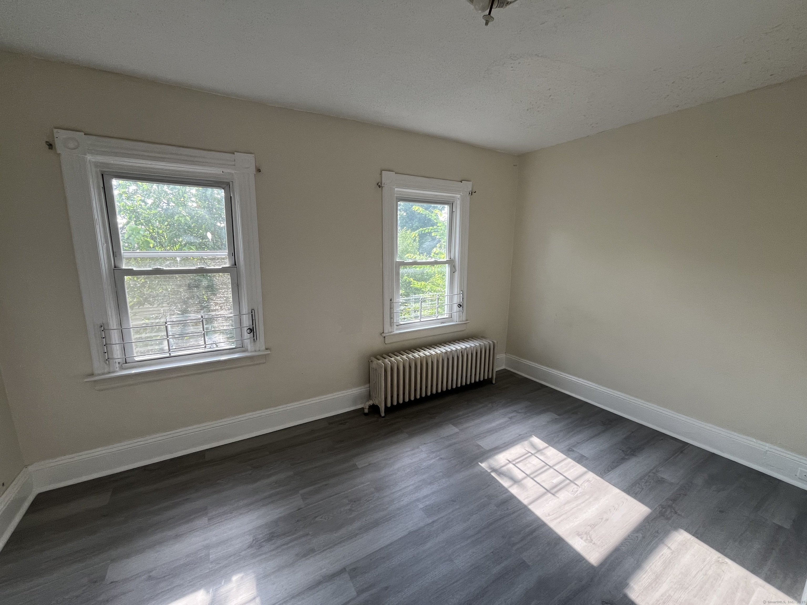 144 Burnham Street, Unit 2 Hartford, CT 06112 - Photo 4 of 11 a view of an empty room with wooden floor and a window