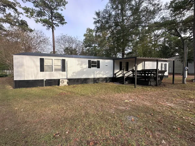 a view of a house with backyard and sitting area