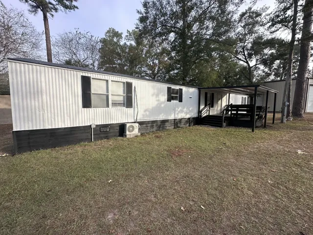 a white house that has a tree in front of it