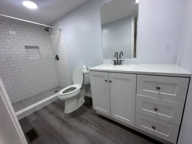 a bathroom with a sink a toilet and shower