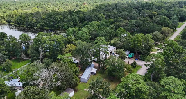 an aerial view of residential house with outdoor space and trees all around