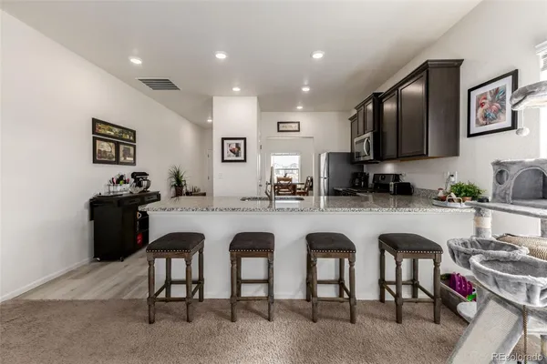 a kitchen with stainless steel appliances granite countertop a table and chairs