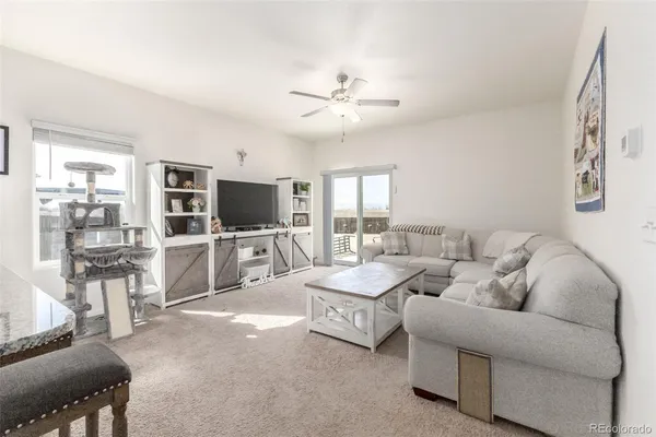 a living room with furniture a flat screen tv and a chandelier