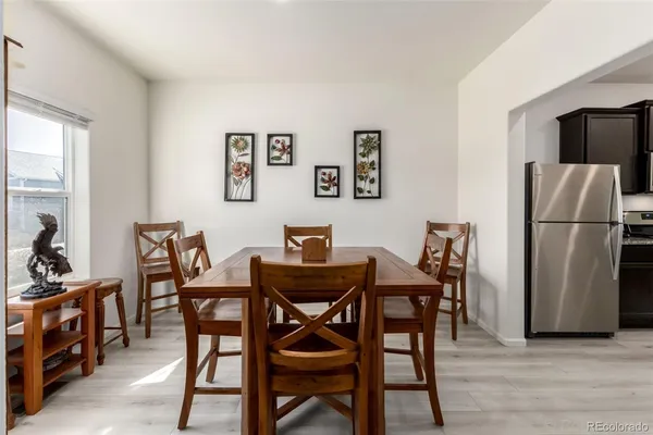 a view of a dining room with furniture and a refrigerator