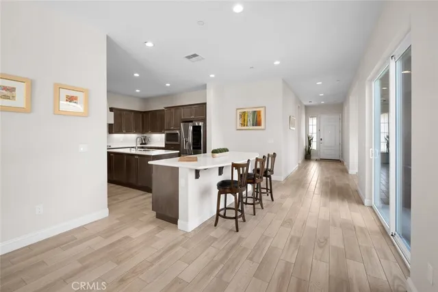 a kitchen with kitchen island stainless steel appliances a sink stove and refrigerator