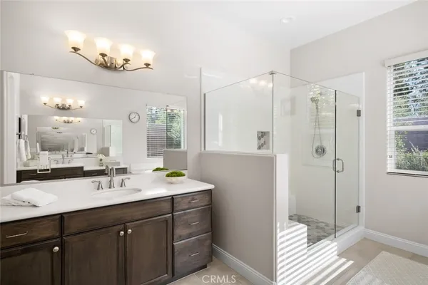 a bathroom with a sink a toilet a mirror a vanity and shower