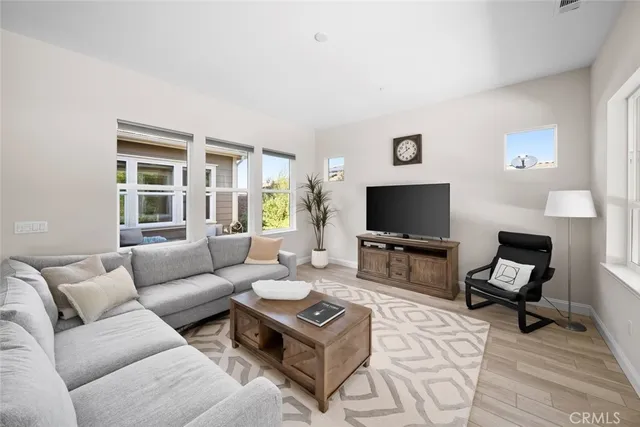 a living room with furniture a flat screen tv and a window