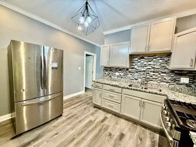 a kitchen with stainless steel appliances granite countertop a refrigerator and a stove top oven