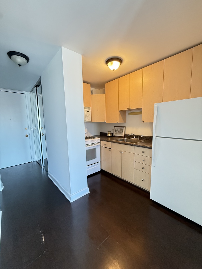 1 East Scott Street, Unit 2102 Chicago, IL 60610 - Photo 3 of 13 a kitchen with a sink a refrigerator and white cabinets
