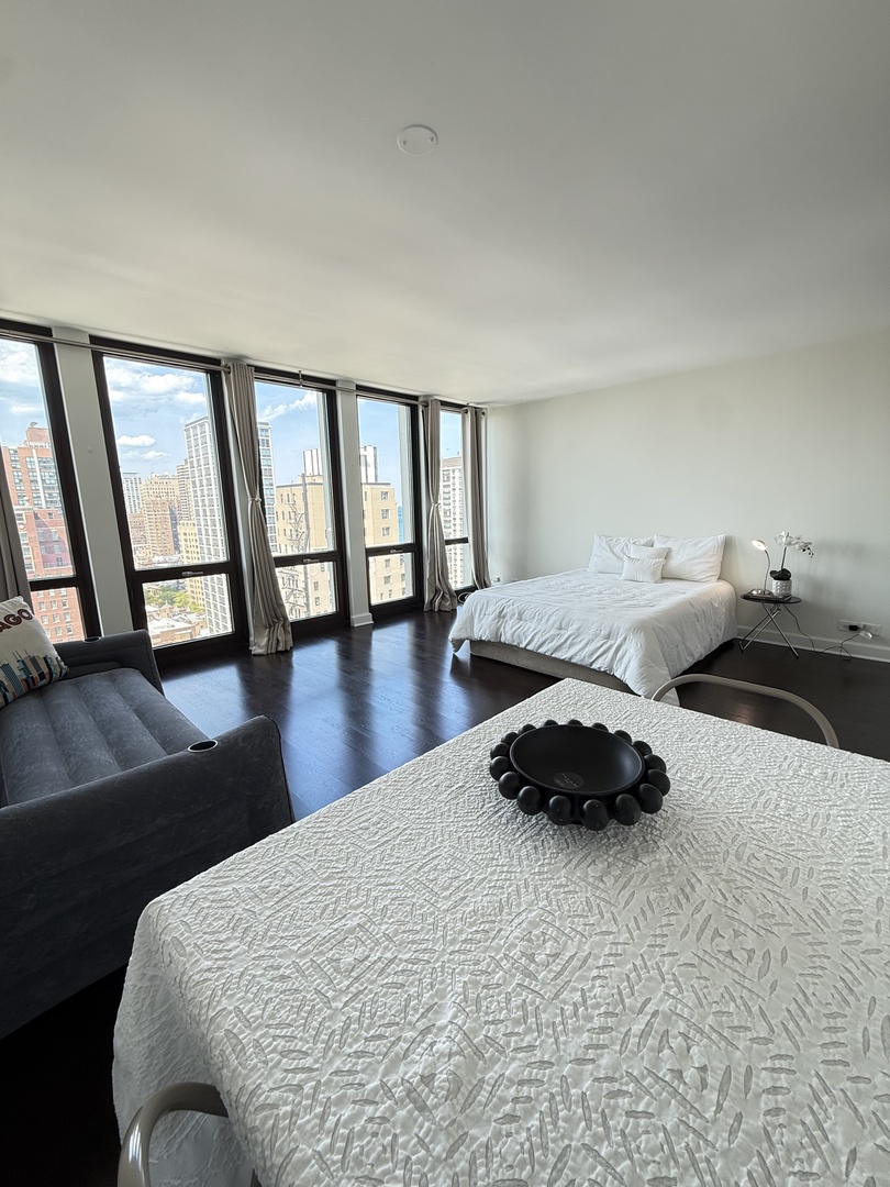 1 East Scott Street, Unit 2102 Chicago, IL 60610 - Photo 6 of 13 a bedroom with a bed a mirror and a window