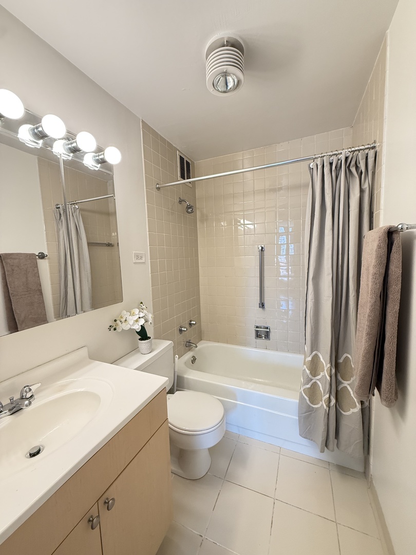1 East Scott Street, Unit 2102 Chicago, IL 60610 - Photo 9 of 13 a bathroom with a double vanity sink toilet mirror and shower