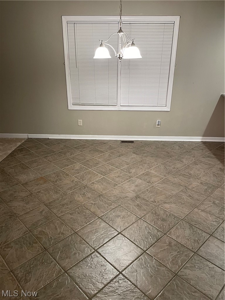 2819 Best Road Cambridge, OH 43725 - Photo 4 of 33 Tiled empty room with an inviting chandelier