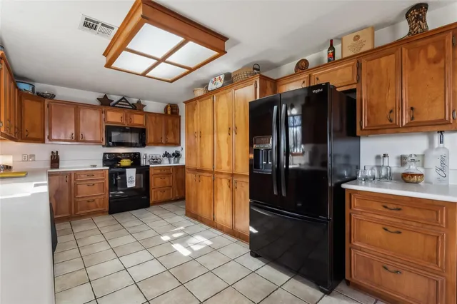 a kitchen with stainless steel appliances granite countertop a refrigerator and a stove top oven